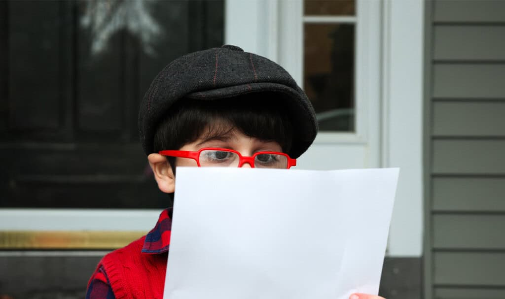 Surprised little boy looking at a letter.